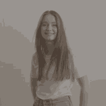 a woman with long red hair wearing a white t-shirt and jeans