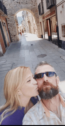a woman kisses a man on the cheek in front of a store that says ' el tony 's shoes '
