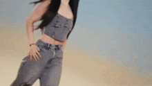 two women are standing next to each other in the desert wearing denim .