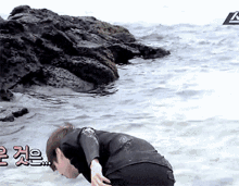 a man in a wet suit is crawling into the ocean