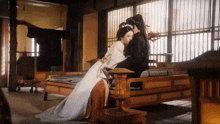 a man and a woman are sitting next to each other on a couch in a room .