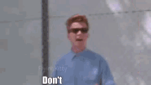a man wearing sunglasses is standing in front of a chain link fence and says `` don 't you '' .