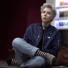 a man wearing striped socks sits on the floor