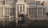 a large white building with columns and a statue in front of it