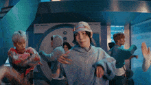 a group of people are dancing in a room with a blue background .