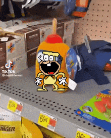 a cartoon character is sitting on a shelf in a store with a bottle of ketchup .