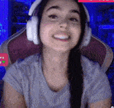 a woman wearing headphones is smiling while sitting in a gaming chair