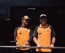 two men wearing orange shirts with dell on the front