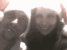 a man and a woman are wearing santa hats and smiling .