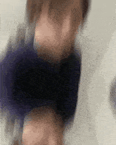 a blurry picture of a person 's face with a blue shirt on