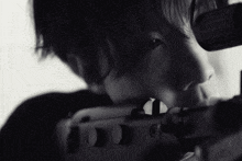 a black and white photo of a person looking through a telescope