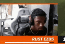 a man wearing headphones is sitting in a chair in front of a computer screen .