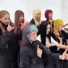 a group of girls with different colored hair are standing in a line