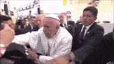 a man in a white hat is being held by a man in a suit .