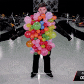 a man is surrounded by balloons and has the word tyranny on the bottom of the photo