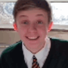 a young boy wearing a suit and tie is smiling .