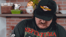 a man wearing a black harley davidson hat