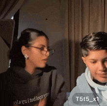 a girl wearing a hoodie that says t5t5_x1 is talking to a boy