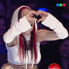 a woman making a heart shape with her hands