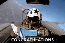 a man in a fighter jet reading a book that says congratulations