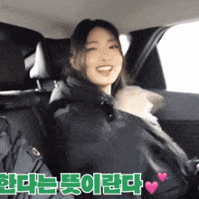 a woman is sitting in the back seat of a car with korean writing on the bottom