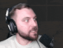 a man with a beard is wearing headphones and a microphone .