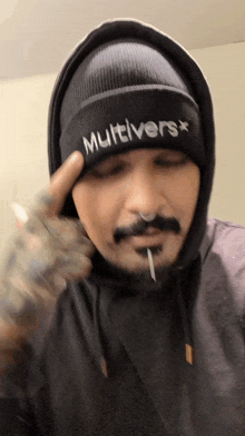 a man wearing a black beanie that says multivers on it