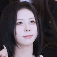 a close up of a woman 's face with a slight smile on her face