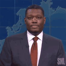 a man in a suit and tie with snl written on his chest