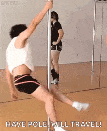 a man is pole dancing in front of a mirror while a woman looks on .