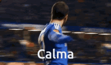 a blurry picture of a man standing next to another man with the word calma written on the bottom