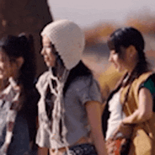 three women are standing next to each other in a line .