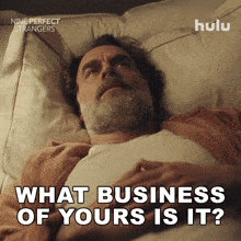 a man is laying in bed with the words what business of yours is it