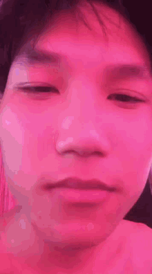 a man without a shirt is standing in front of a pink light