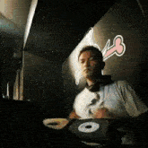 a man wearing headphones is playing music in a dark room