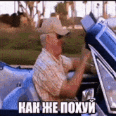 a man wearing a hat and sunglasses is driving a car with the words " как же похуй " below him