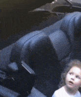 a little girl is sitting in the back seat of a plane