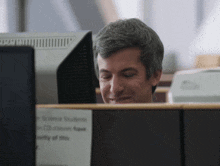 a man sits at a desk with a sign that says " science students "