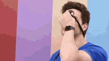 a man wearing an apple watch is covering his face with his hand
