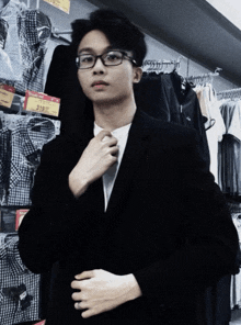 a man in a suit adjusts his tie in front of a price tag that says 318