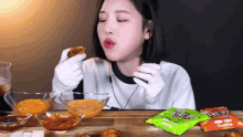 a woman in white gloves is eating a piece of food from a bag that says goodbye