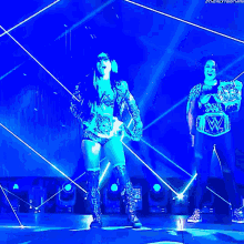 two female wrestlers are on a stage and one has a wwe belt