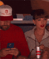 a woman wearing red lipstick is sitting next to a man wearing a pink shirt