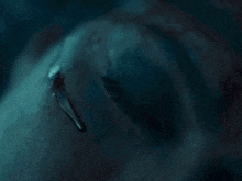 a close up of a person 's blue eye with a tear running down it