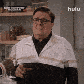 a man is holding a glass of wine in front of a hulu ad