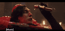 a man is holding a lightsaber in front of his face and the word music is on the bottom right