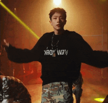a young man is wearing a black sweater that says new york