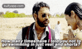 a man with a beard is talking to a woman in a field while wearing sunglasses and shorts .