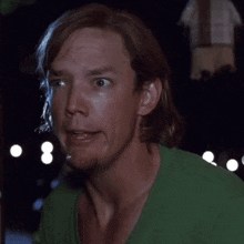 a man in a green shirt with the words say what written below him