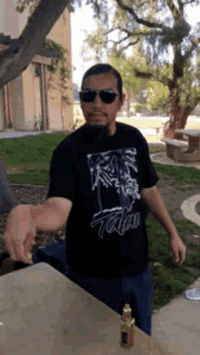 a man wearing sunglasses and a t-shirt that says ' aloha ' on it
